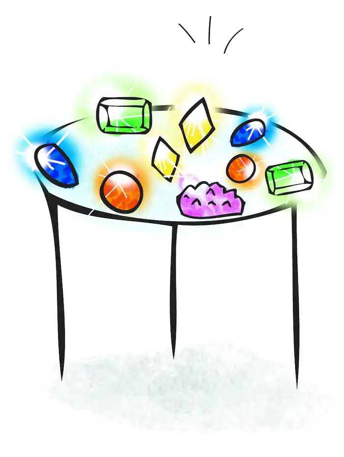 Blue, green , pink and red gems lay on top of a small round table